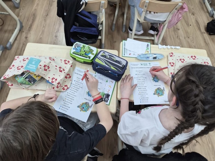 Copii rezolvând jocuri educative despre reciclare la atelierul ECOarena Iași
